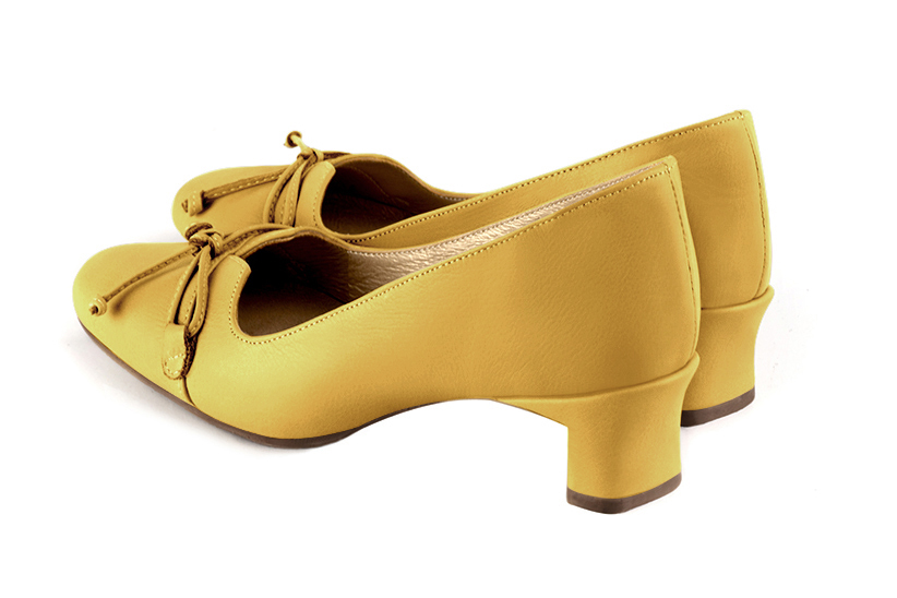 Mustard yellow women's dress pumps, with a knot on the front. Round toe. Low kitten heels. Rear view - Florence KOOIJMAN